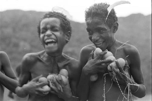 Boys laughing and holding cucumbers