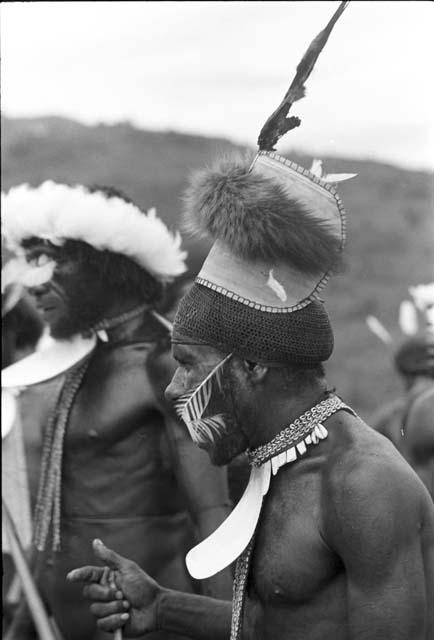 Tegé Warek in an inamossi and mikak; behind him is Weaklekek in his beautiful white kara kara