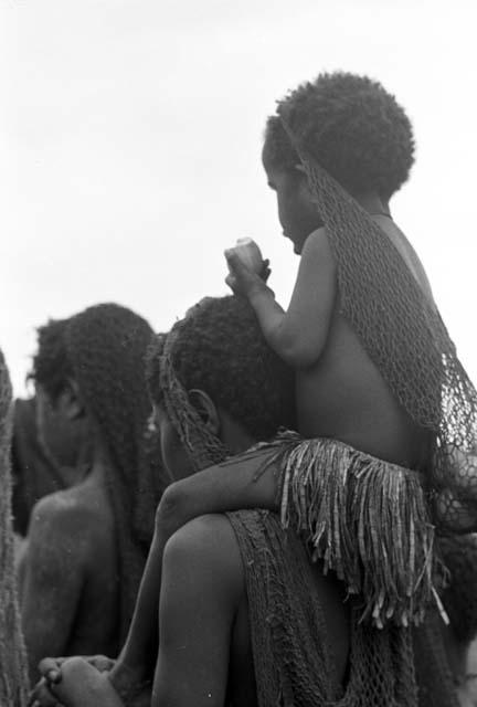 Woman carrying child on her shoulders