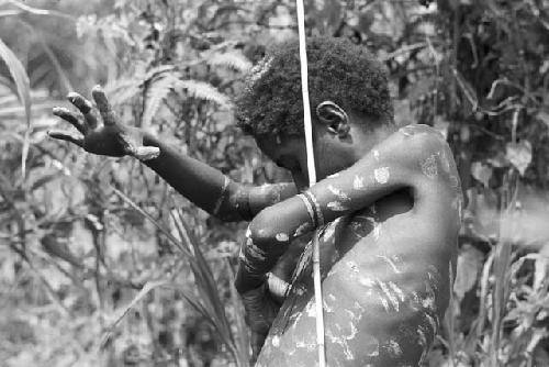 Child painting dotsof clay on his body