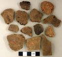 Coarse earthenware body and rim sherds, some cord impressed, some incised