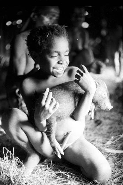 Tukom holding a pig inside of a hunu