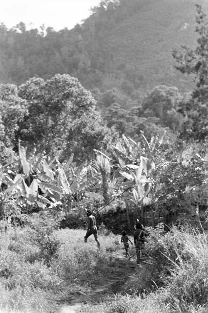 Two men and a child walking towards the sili