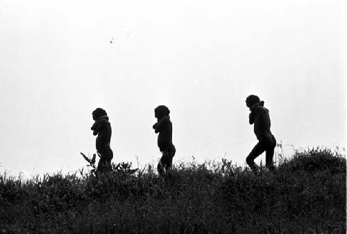 3 little boys walking along; hands behind their necks on the salt trail going south