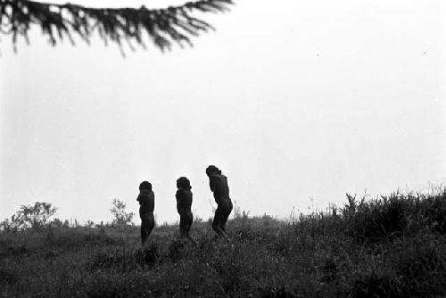 3 little boys walking along; hands behind their necks on the salt trail going south