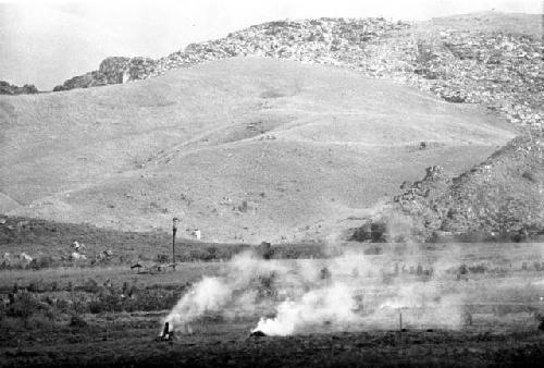 Distant view over the valley; burning of trash in the frgd; kaio in the distance and the Supula in the bkgd