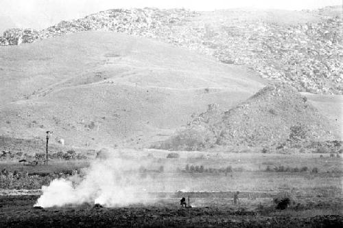 Distant view over the valley; burning of trash in the frgd; kaio in the distance and the Supula in the bkgd