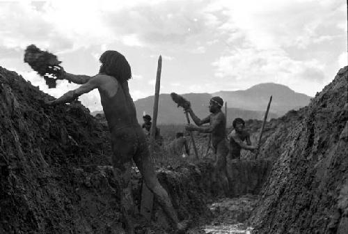 Men throwing trash out of the ditch