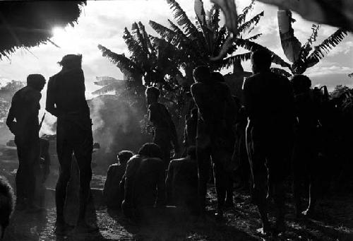 Silhouette shot of men mourning at the funeral for a woman at Abulupak