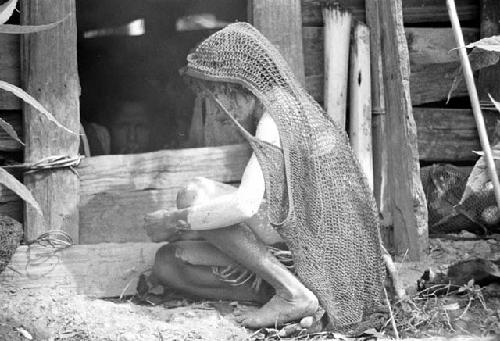 A woman outside the hunu at Abulupak