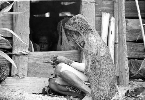 A woman outside the hunu at Abulupak
