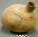 Egg-shaped jar; narrow neck protruding diagonally off one end, rim chipped, body