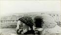 Woman bending and using Zuni oven