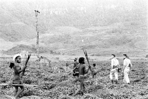 View towards the Anelerak near Wali's kaio; warriors in foreground; Karl Heider and Robert Gardner in the middleground