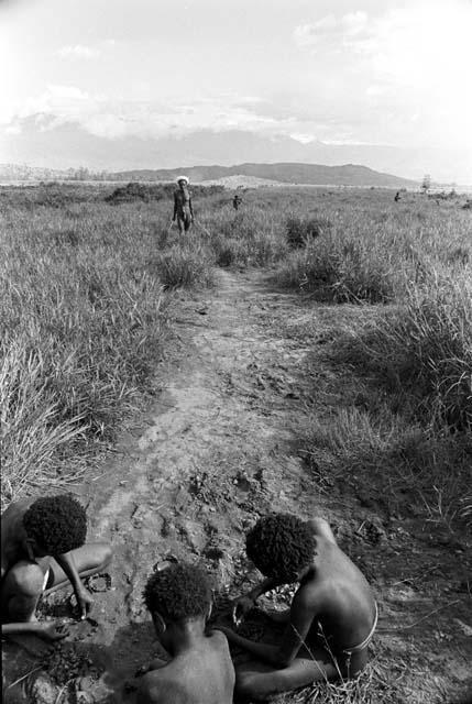 Children in forerground; Asuk coming in direction of the Watibara towards them