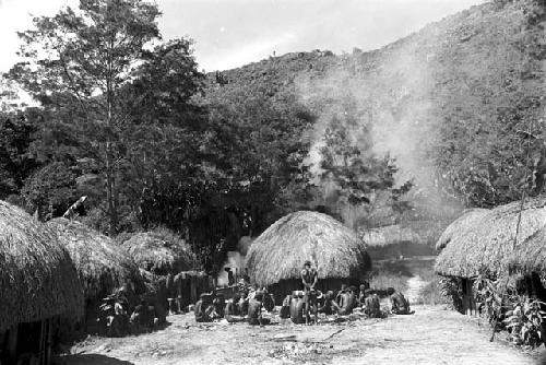 Distance shot of whole sili; men are butchering the pig