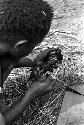 Young boy with a charred rat in his hand