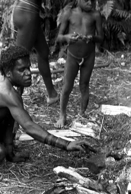 Older man taking rats off of hot stones