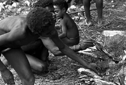 Young boys placing their rats on hot stones