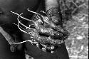 Man holds about a half dozen charred rats in left hand