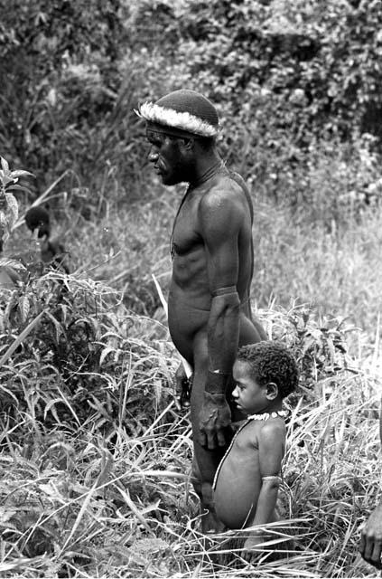 Itlai and his daughter watch as the men hunt for mice