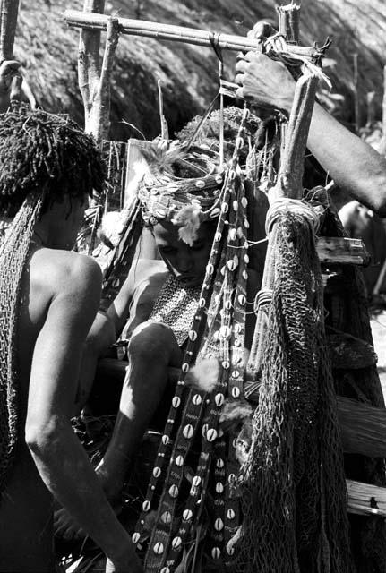 Huonke drapes a string of cowrie shells on Weaké