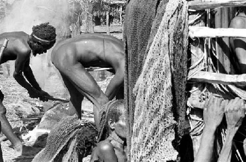 Pigs being singed in back of the dead boy