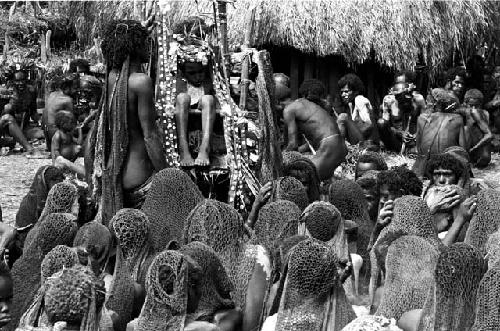 Over heads of women at the dead boy; men behind