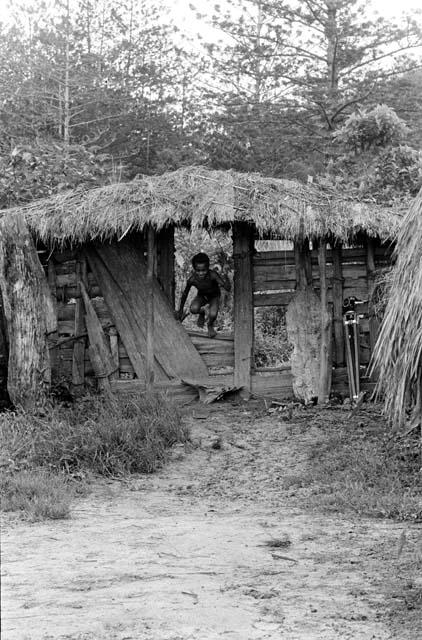 Boy coming into the sili thru the entryway of Abulupak