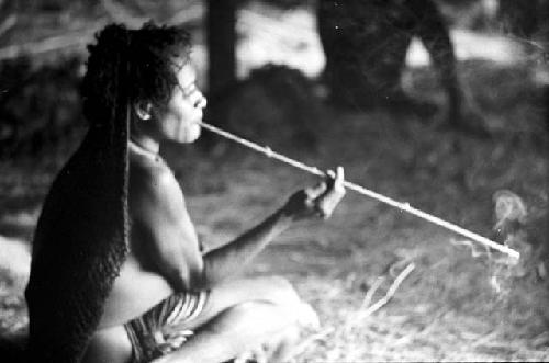 Woman smoking thru a long reed cigarette holder