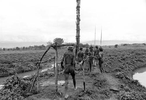 Men who are on their way out to a war on the Tokolik pass Wali's burned kaio