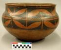 Large pottery jar. Black on red design on upper portion. 9" (height); 12.75" (