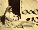 Hopi woman polishing pottery
