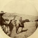 Hopi man riding a horse, and a Hopi woman riding a donkey