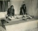 Two Hopi women grinding corn