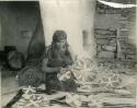 Hopi woman weaving baskets