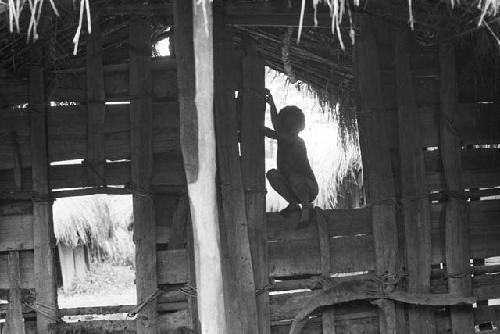 Child sits in a gateway to a sili