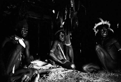 3 men seated in honai