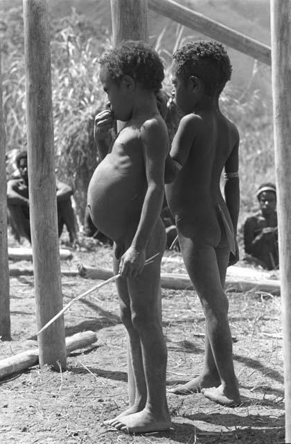 2 little children watch as the building goes up; Kibit Silimo; RC school