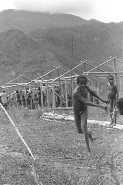 Children beginning to play sikoko wasin; school building going up in the background