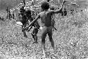 Children beginning to play sikoko wasin; school building going up in the background