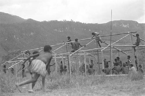 Children beginning to play sikoko wasin; school building going up in the background