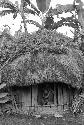 Woman and child look out the doorway of a ebeai