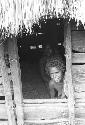 Two women look out of doorway of hunu