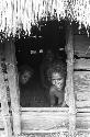 Two women look out of doorway of hunu