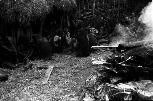 Women mourning beside the fire