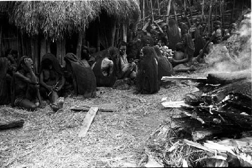 Women mourning beside the fire