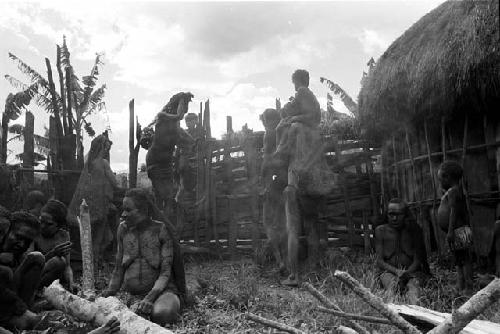 Women beginning to leave with their children, looking towards the entryway of the sili