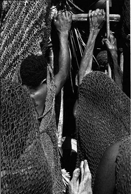 Hands of women clutching onto the chair of the dead boy