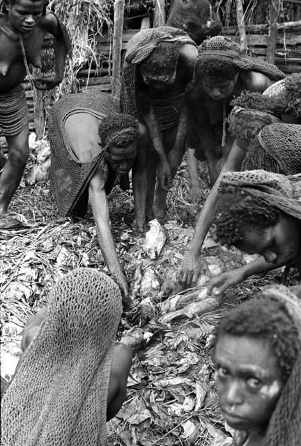 Men working in hakse; taking out some potatoes